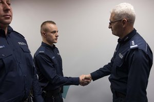 Zdjęcie kolorowe. Komendant Wojewódzki Policji w Katowicach nadinsp. dr Krzysztof Justyński wraz ze swoim Zastępcą gratuluje wyróżnionym policjantom