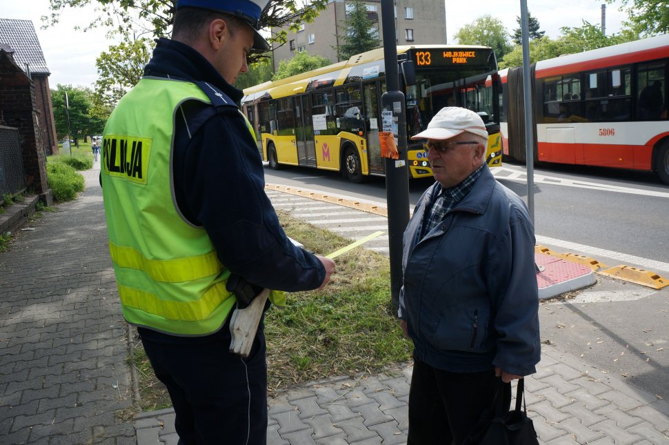 policjant wręcza pieszemu odblask