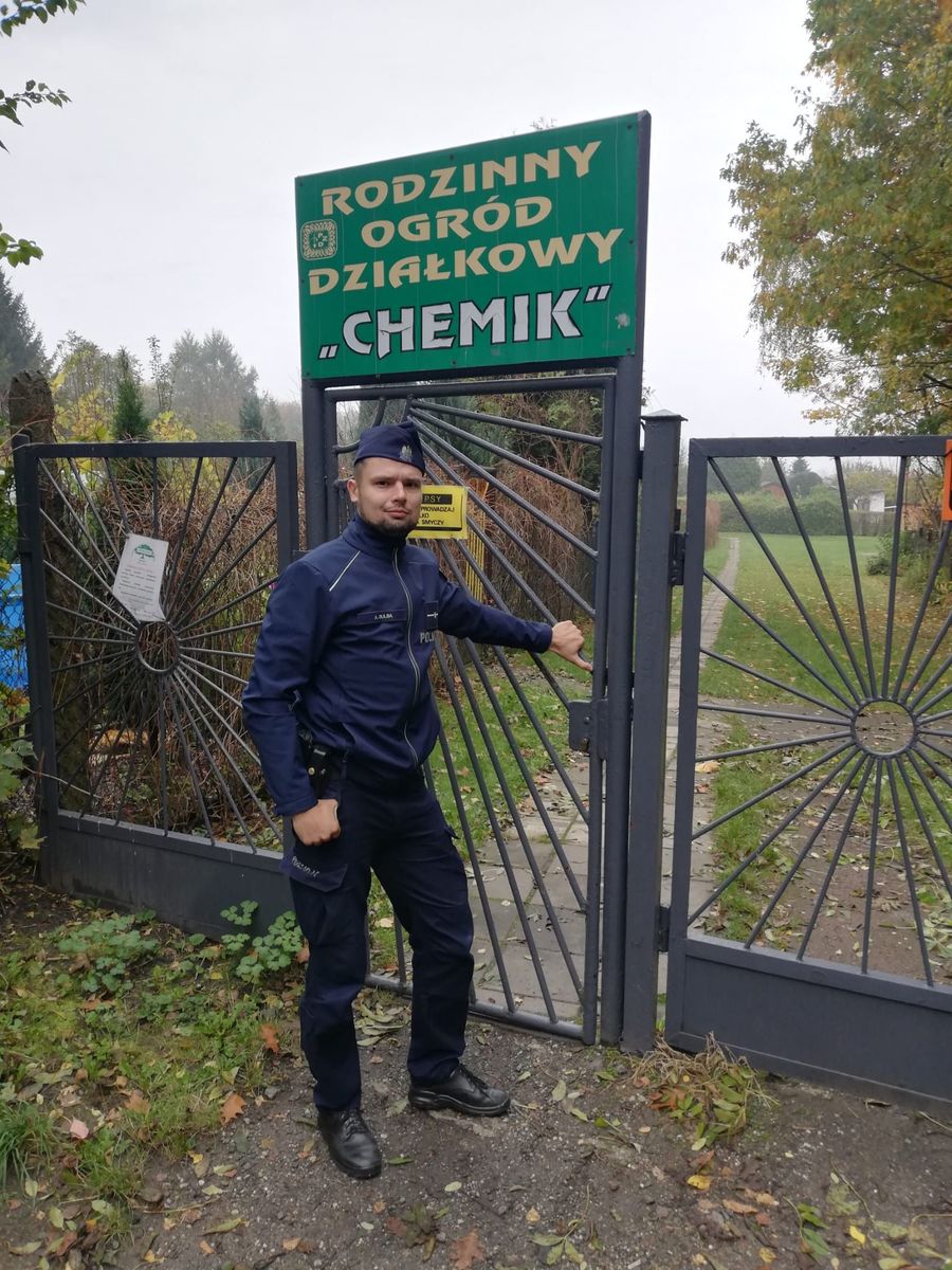 na zdjęciu dzielnicowy przy bramie wejściowej do ogródków działkowych