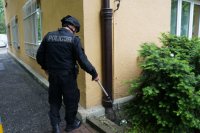 policjant szuka ładunku wybuchowego