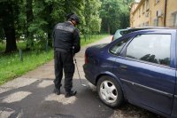 policjant szuka ładunku wybuchowego