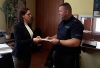 policjant wręcza plakaty
