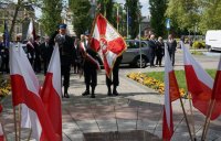 sztandar straży pożarnej przed pomnikiem