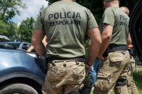 policjanci w umundurowaniu stoją tyłem