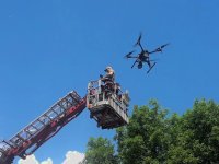 policjant na wysięgniku wozu strażackiego puszcza drona