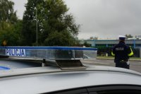 lampa radiowozu z napisem Policja a w tle policjant