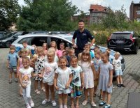 policjant z dziećmi przy radiowozie