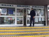 dzielnicowy stoi przy drzwiach biblioteki