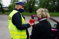 policjant wręcza laurkę kobiecie