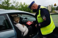 policjant wręcza laurkę kobiecie