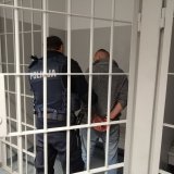 policjant z podejrzanym za kratkami