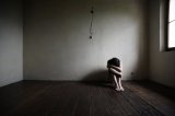 kobieta siedząca na podłodze w pustym pokoju