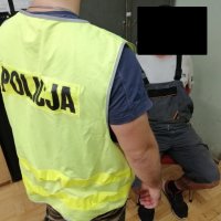 policjant stoi koło zatrzymanego