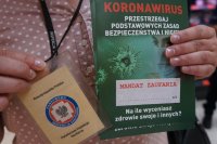 legitymacja pracownika sanepidu i ulotki związane z koronowirusem