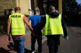 policjanci prowadzą zatrzymanego