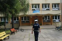 policjant wchodzi do budynku szkoły
