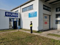 policjant stoi przed stacją diagnostyczną
