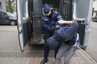 policjant prowadzi zatrzymanego