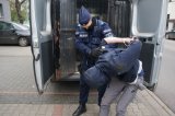 policjant prowadzi zatrzymanego