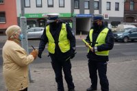 policjanci wręczają odblaski kobiecie