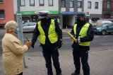 policjanci wręczają odblaski kobiecie