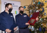 wyróżniony policjant stoi z I Zastępcą Komendanta, który trzyma grawerton