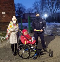 policjant z wolontariuszem na wózku inwalidzkim i jego opiekunem