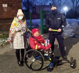 policjant z wolontariuszem na wózku inwalidzkim i jego opiekunem