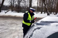 policjant z drogówki stoi przy kontrolowanym samochodzie
