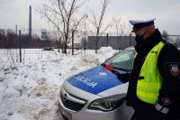 policjant z drogówki stoi przy radiowozie