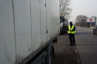 policjant stoi z tyłu samochodu ciężarowego