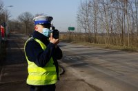 policjant mierzy radarem na drodze