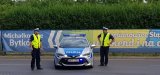 policjanci stoją obok radiowozu
