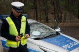 policjant z drogówki stoi przy radiowozie