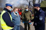 policjanci wręczają kierowcy odblask, obok stoi prezes Fundacji Grot