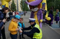 policjant wręcza opaskę odblaskową dziecku