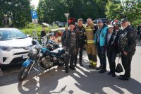 motocykliści i strażak stoją obok siebie