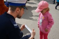 policjant wręcza dziecku odblask