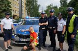 Tomasz Dzierga, policjanci z ruchu drogowego, dzielnicowi w stroju rowerowym stoją koło radiowozu