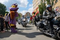 maskotki i jadące motory po ulicy, które asystowały rowerzystę