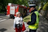 policjant wręcza pieszej odblask i ulotkę