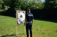 policjant stoi przy tarczy, do której oddawał strzały