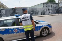 dowódca działań policyjnych stoi przy radiowozie