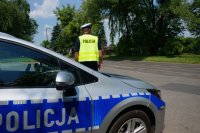 policjant stoi przy radiowozie