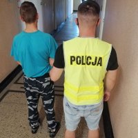 policjant prowadzi zatrzymanego