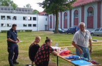 policjant z ratownikami wodnym podczas spotkania na terenie otwartym