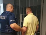 policjant trzyma zatrzymanego