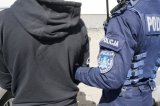 policjant prowadzi zatrzymanego