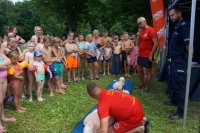 ratownicy wodni pokazują dzieciom na fantomach udzielanie pierwszej pomocy