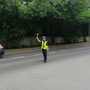 policjant na drodze wydaje sygnał do zatrzymania się